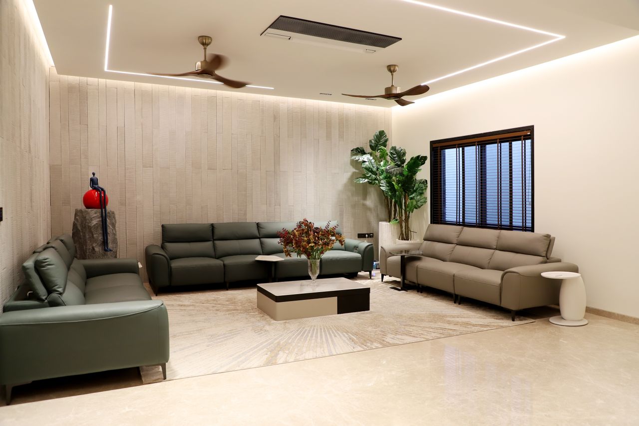 Spacious modern living room featuring green sofas, indoor plants, and minimalistic decor.